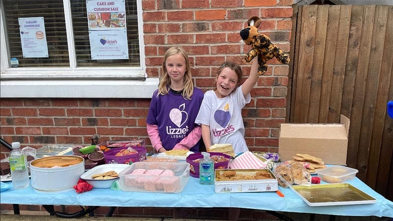 Daisy and her cousin selling cakes at her stall