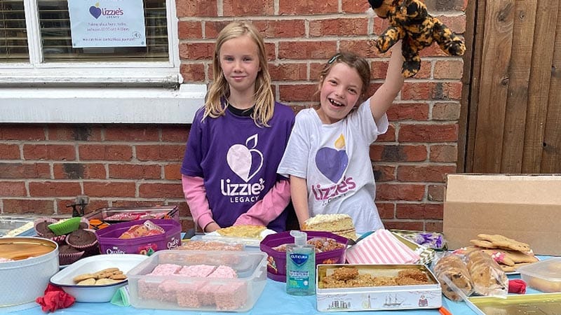 Daisy and her cousin selling cakes at her stall